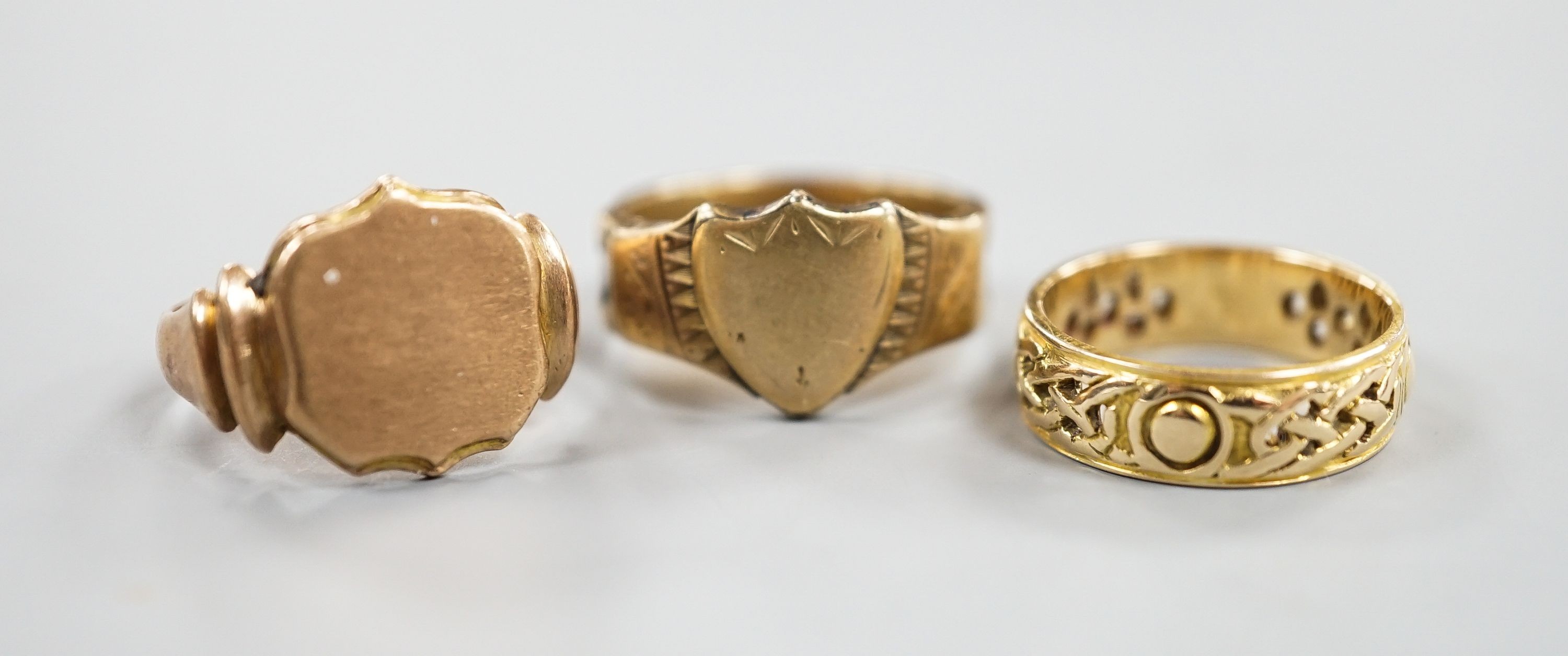 A Scottish pierced 14ct gold band, hallmarked for Edinburgh, 1962?, maker G & TW, size K/L, 3.8 grams and two 9ct gold signet rings, including one with plaited hair within the shank, hallmarked for Chester, 1881, gross 8